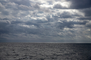 Fototapeta premium Sea with dramatic rainy clouds and sun beams.