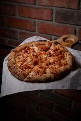 Delicious American chicken pizza with bbq on a wooden board.
