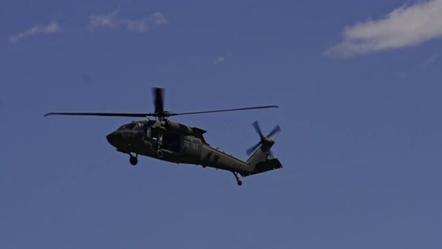 View Of Sikorsky UH-60 Black Hawk Flying In Air Against Blue Skies. Slow Motion, Tracking Shot