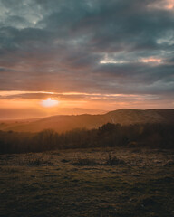 A beautiful sunset landscape with a sea view and mist over the cliffs