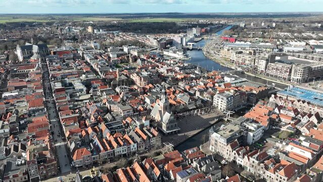 An aerial view of Alkmaar's historic center, showcasing the impressive De Grote Sint Laurenskerk and the bustling Waagplein.
