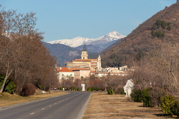 Fototapeta premium Panorama of Digne les Bains, Alpes de Haute Provence, France, with the tower of the Cathédrale Saint-Jérôme (Saint Jerome cathedral) and the snowy Alps Mountains in the background.