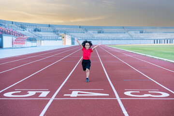Little girl at athletics competition race. A girl running in stadium.