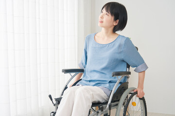 Obraz na płótnie Canvas リビングで車椅子を使う女性