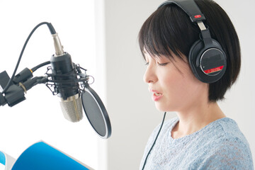 スタジオでナレーションを録音する女性ナレーター
