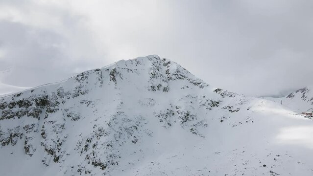 Panning Slowmotion panoramic drone shot of the top lift of the Bansko Ski Resort, in Pirin Bulgaria