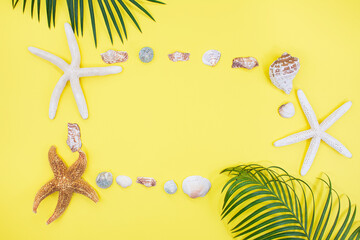 Fototapeta na wymiar Starfish, shells in form of frame with palm tree on yellow background. Vacation, travel concept. Copy space