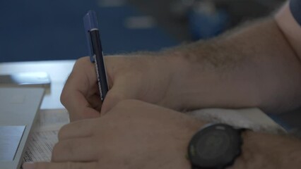 close up of a businessman filling in a form on his desk in a rugby gym in Montpellier, France. - Powered by Adobe