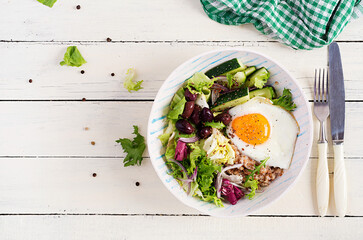 Breakfast wheat porridge with  roasted egg, cucumber and olives. Healthy balanced food. Top view, flat lay