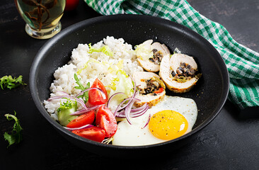 Fried egg, meat chicken roll, rice and tomatoes. Paleo breakfast.