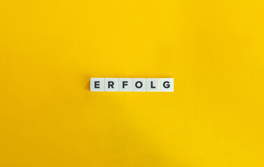 Erfolg Word (Success in German Language). Letter Tiles on Yellow Background. Minimal Aesthetics.