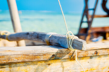 Near a tropical island, a traditional Zanzibar fishing boat lies in clear water close to the beach, perfect for summer travel and fishing boats