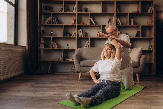 Portrait of happy senior couple performing exercise at home.