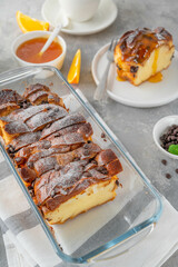 Homemade bread pudding with chocolate chips on a gray concrete background. Selective focus, copy space.