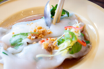 Chinese steamed tube noodles in a yellow bowl, a popular Thai breakfast.