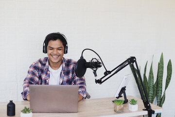 Attractive young Asian man radio host talking during podcast. Copy space. 
