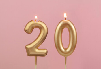 Burning golden birthday candles on pink background, number 20 - obrazy, fototapety, plakaty