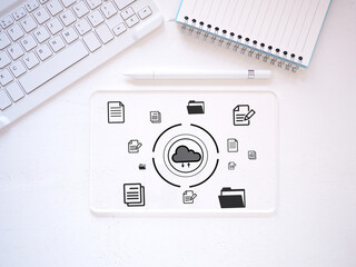 Transparent virtual tablet PC with icon document data technology and cloud computing and efficient online storage on white desk, keyboard, stylus pen, notebook. Top view, flat lay..