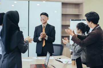 Group of business people make applause at office meeting room, against successful manager background. 