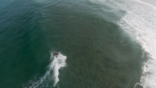 Bodyboarder takes off on open wave faces and performs 360 spin trick and rollo