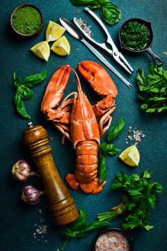 Top view of whole red lobster with lemon, basil and spices. Free space for text.