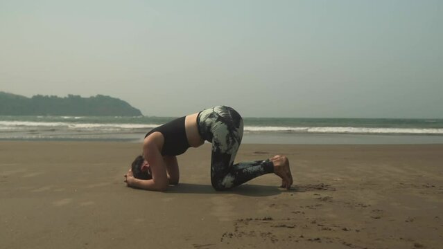 Yoga headstand position asana by young woman on beach outdoors exercise Sirsasana