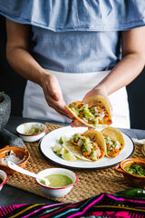 Mexican woman hands preparing tacos al pastor and eating mexican food in Mexico Latin America