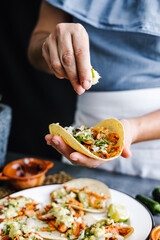Mexican woman hands preparing tacos al pastor and eating mexican food in Mexico Latin America