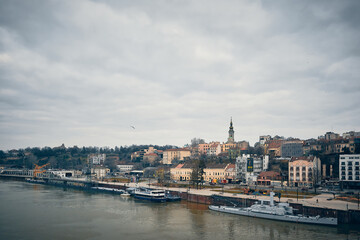 Fototapeta premium Panoramic view of Sava river embankment with moored ships and vessels and Saint Michael's Cathedral, Belgrade, Serbia