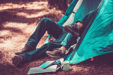 Couple inside a tent in free camping nature woods and travel lifestyle. People enjoying outdoor leisure activity, Traveler inside blue tent. Freedom people and nature lifestyle. Alternative vacation