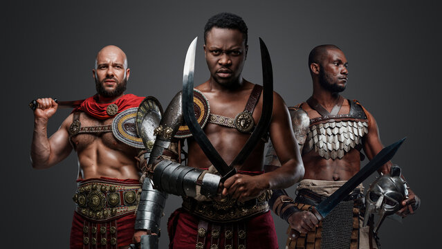 Studio shot of muscular greek soldier fromt past with armor and cold steel.