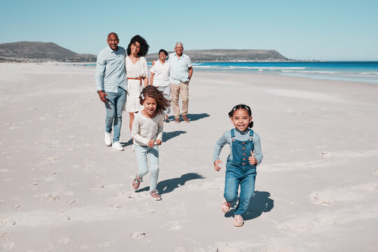 Beach, family and portrait of kids running in sand, playful and having fun while bonding outdoors. Face, children and parents with grandparents on summer vacation at sea on ocean trip in Cape town