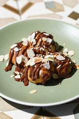 Chocolate Profiteroles with pistachio on plate