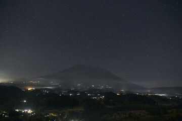 Night Volcano Agung. Tropical Volcanic Mountains In Night Lights. Active Volcano With Crater. Evening Landscape With Dark Sky