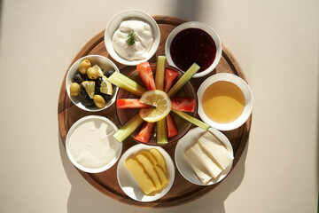 Obraz na płótnie Canvas Breakfast tray with cheese, honey, jam and fresh vegetable