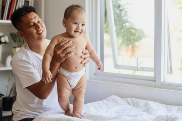 Happy father with adorable baby playing at home 