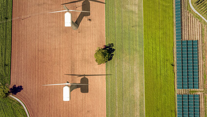Overhead drone shot of wind turbines in a field. © neil
