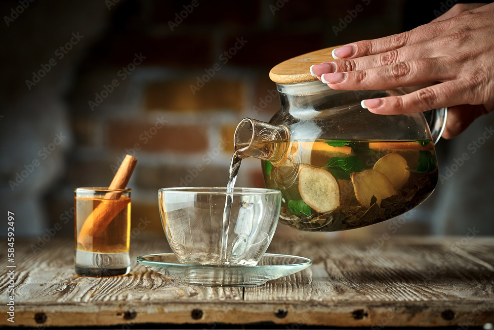 Wall mural green tea with fruit is poured from a teapot into a cup