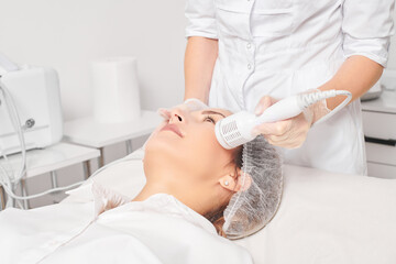Cosmetologist makes cryotherapy for rejuvenation woman face, anti aging cosmetic procedure with in...