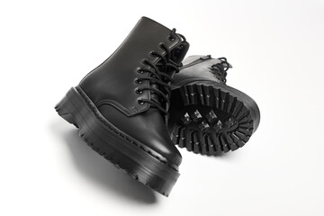 Black women combat boots on high heel platform with lug soles lying on isolated white background....