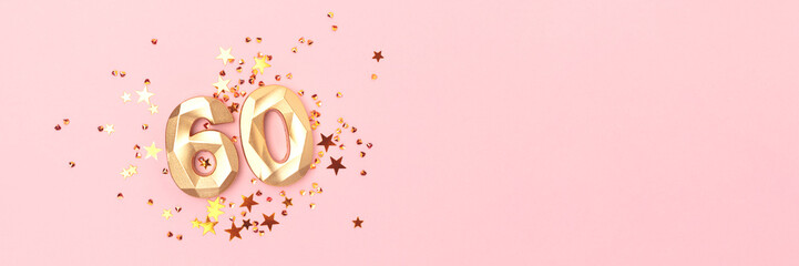 Banner with gold colored number sixty and stars confetti on a pink background. Creative concept...