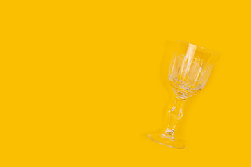 Vintage crystal glass on a yellow background. Minimal composition with copy space.