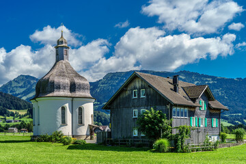 Sommerhimmel über dem Bregenzerwald; Lingenau, St.-Anna-Kapelle mit Bregenzerwäderhaus