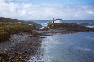 Atlantic Ocean Coastline. Galicia, Spain. Scenic view of a white chapel on top of a rock and a...