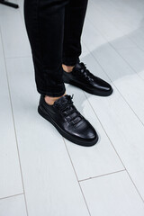 Close-up of male legs in black leather casual sneakers. Comfortable men's demi-season shoes