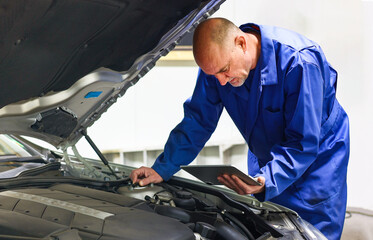 Car Mechanic Detailed Vehicle Inspection using digital tablet assistance the Inspecting the...