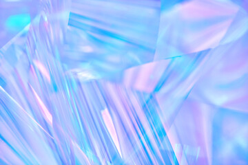 Soft focused, blur close-up of ethereal pastel neon blue, purple, lavender holographic metallic foil background. Abstract modern surreal futuristic disco, rave, techno, festive dreamlike backdrop