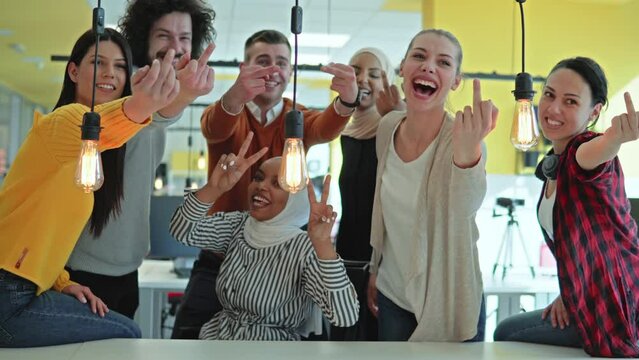 Multicultural happy business team making obscene gesture showing the middle finger