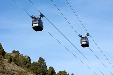 Obraz premium two cabins of funicular in high mountains, winter ski resort. Winter sports, recreation and travel
