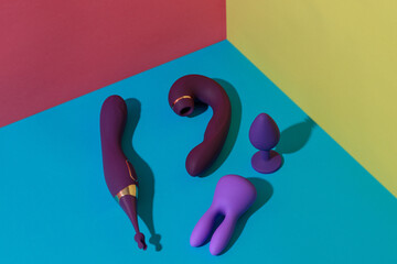 Top view of buttplug and dildos vibrator for sex on colored background. Sex shop concept